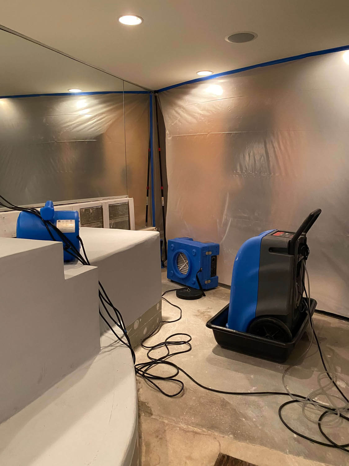 Dehumidifiers and air movers drying a room